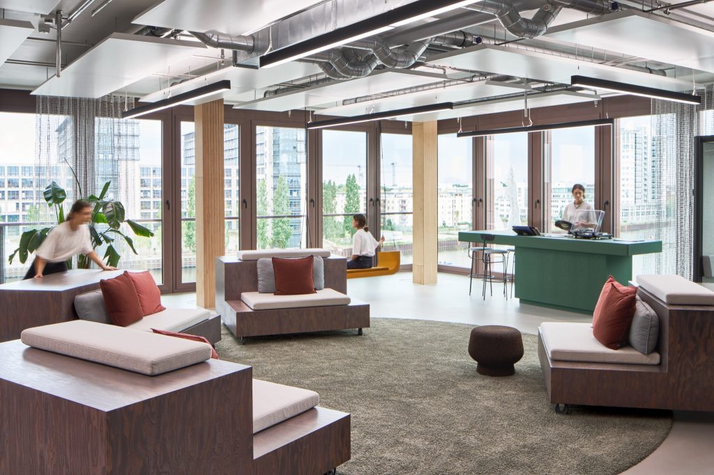 Marketing suite with plywood block seating, a green DJ desk with turntable, a hanging swing chair and Spree views