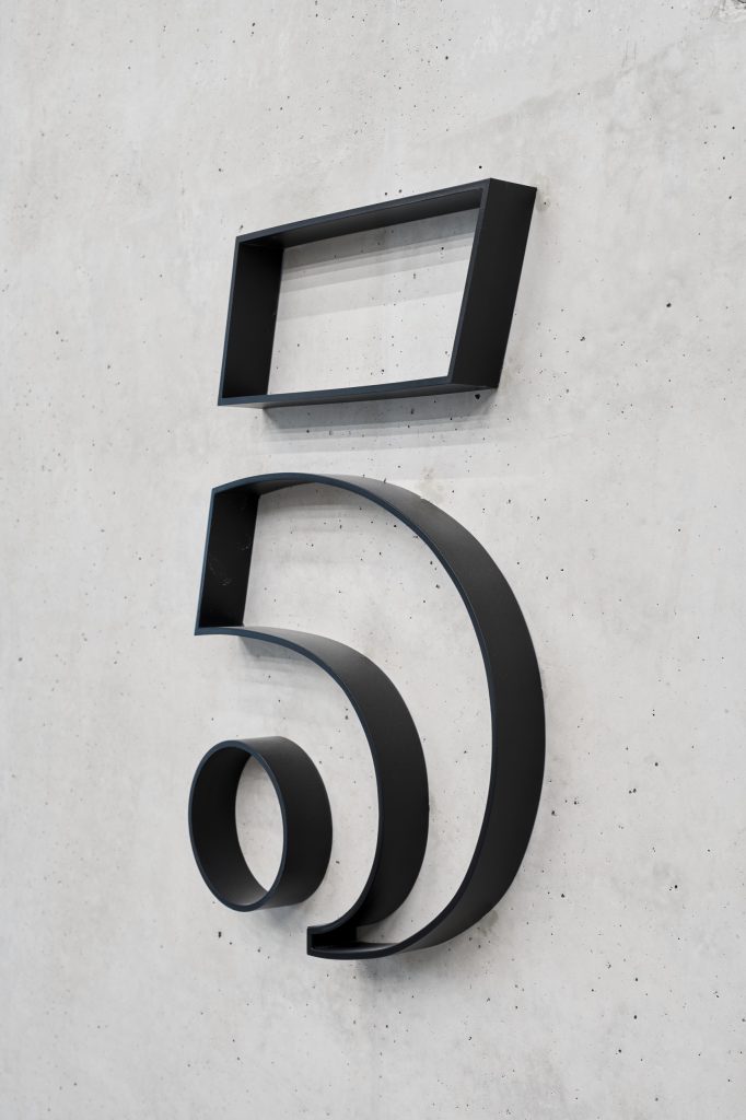 Close view of the bent-steel numeral five, its counters left open