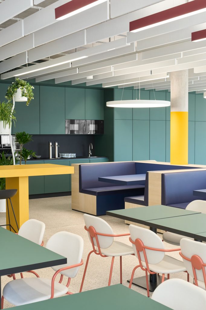 Tea point with teal cabinetry, a yellow high table, blue leather booths and coral chairs under a baffled ceiling