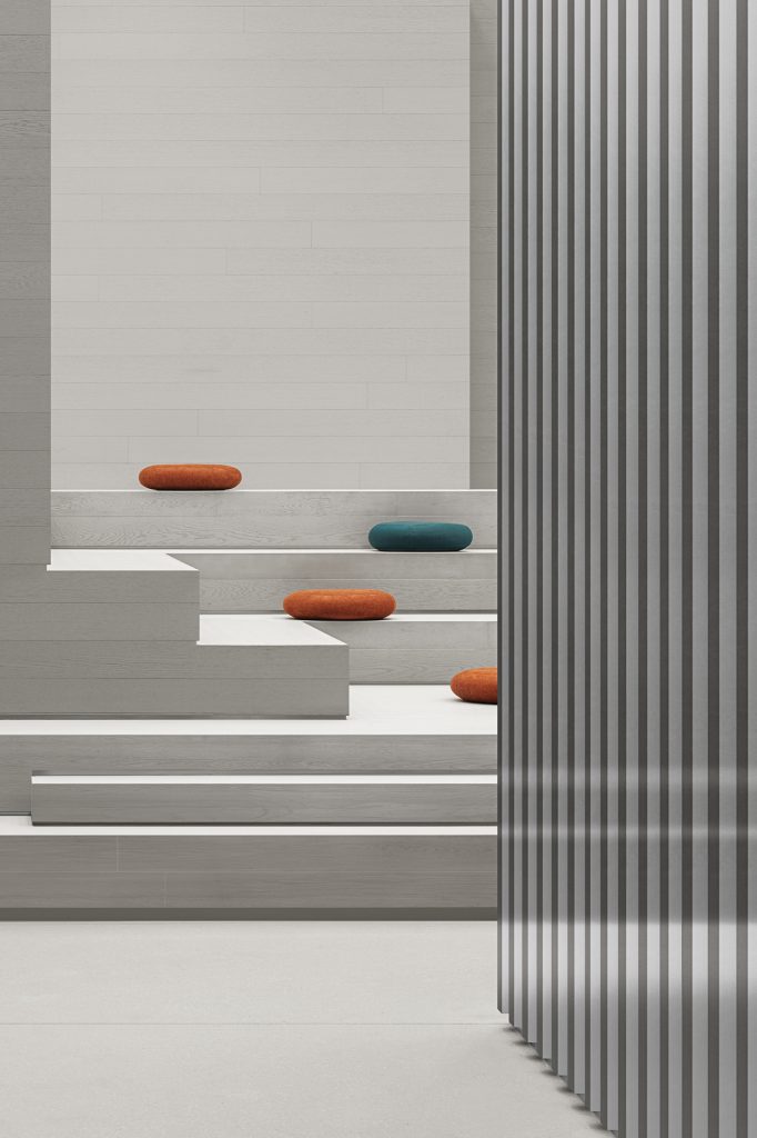 Stepped seating platforms beside a metal-slat screen, felt pebble cushions on the treads