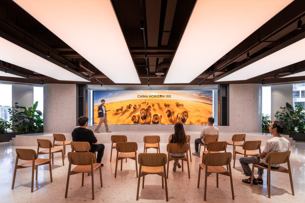 Rows of timber chairs facing a curved LED wall during an event in the Grand Pantry