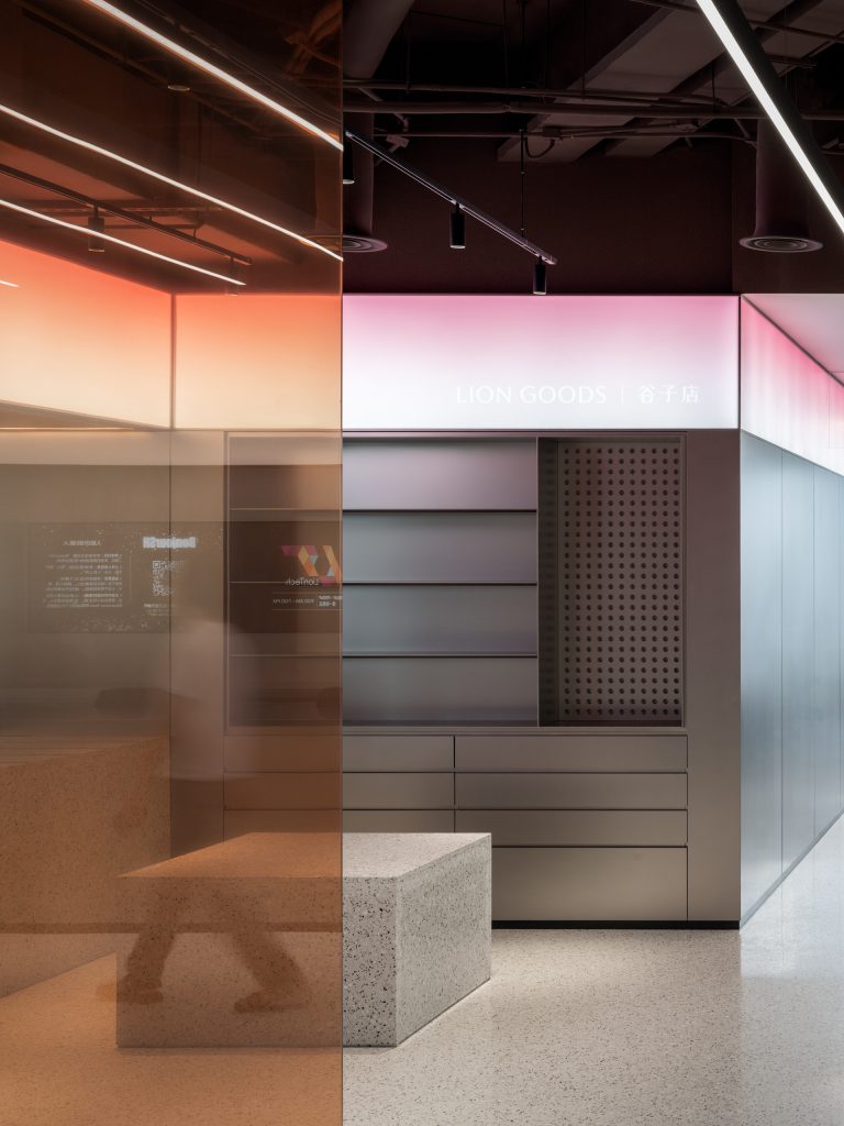 The Lion Goods store with steel shelving and pegboard beneath a pink gradient light band