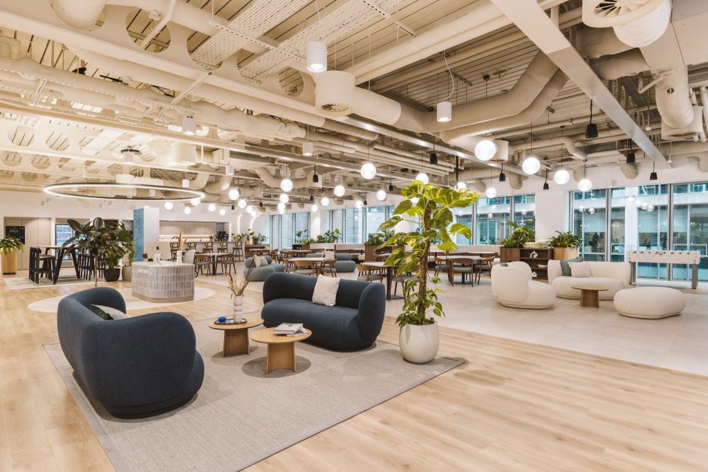 Curved navy and ivory sofas around timber coffee tables, a foosball table by the windows