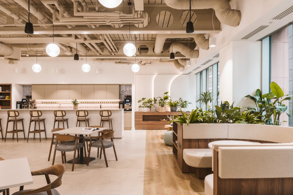 Tea point with tiled splashback and long shelf, curved booth seating and planting to the right